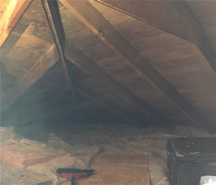 an attic with grey and white discoloration on the wood planks