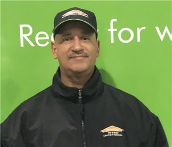 a man in front of a green SERVPRO background