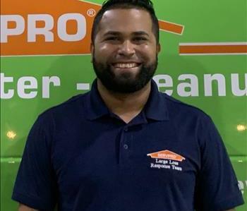 a man in front of a green SERVPRO background