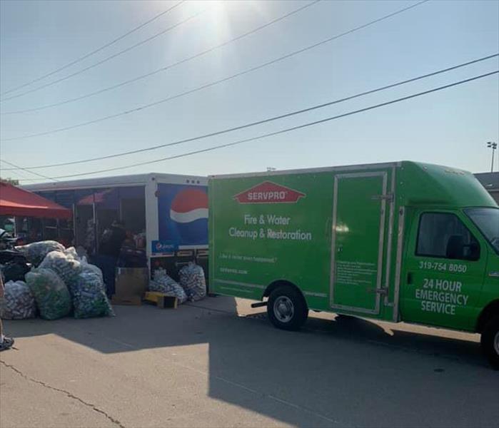 Green SERVPRO truck next to a Pepsi truck. 