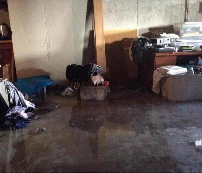 Wet floor of a basement, personal belongings wet, flooded basement