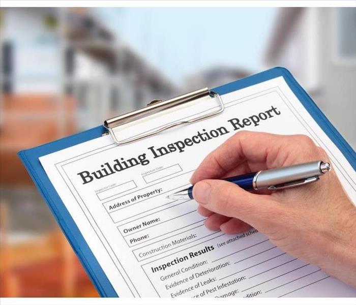 Clipboard with a form that says Building Inspection Report 